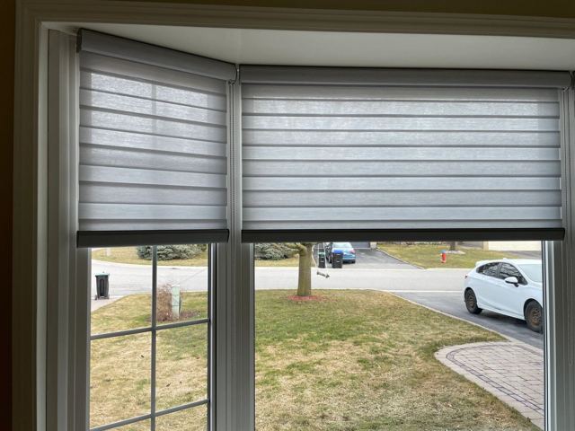 Layered shades across a bay window