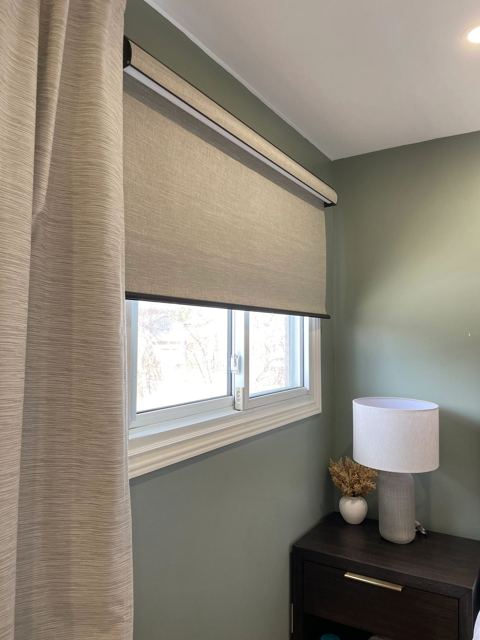 Roller shade with drapes in a bedroom